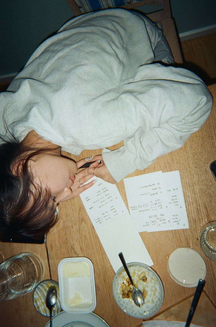 Summer resting her head on a table next to handwritten notes